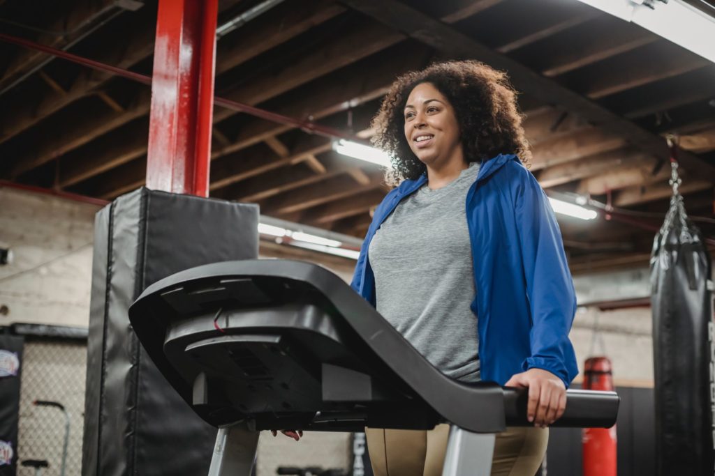 Woman standing on a tredmill resting from her run
